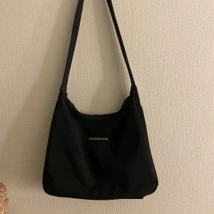 Svart axelväska från David Jones - Snygg svart axelväska från David Jones med en stilren design. Väskan har 3 extra fickor, på insidan, baksidan och även en på sidan. ✨