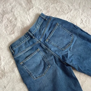 Blå jeans från ASOS Design - Snygga blå jeans från ASOS Design med hög midja och klassisk femficksdesign. Tillverkade i 100% bomull för en autentisk denimkänsla. Perfekta för en avslappnad stil. Alldrig använda