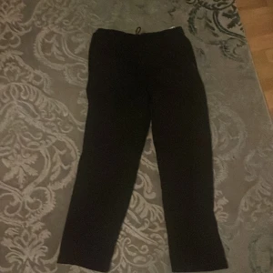 Svarta mjukisbyxor från Somon - Säljer ett par svarta mjukisbyxor från Somon. Byxorna har en bekväm passform med snörning i midjan för justerbarhet. Perfekta för en avslappnad stil.