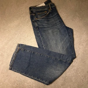Blå jeans - Snygga blå jeans med klassisk design och fem fickor. De har en rak passform och är perfekta för en avslappnad stil. Jeansen har en knappgylf och är tillverkade i slitstarkt denim. Pris går att diskutera!