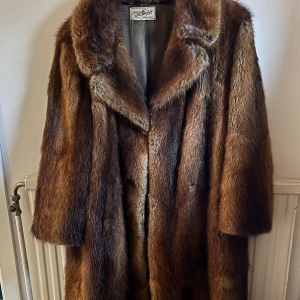 Vintage Brun pälsjacka från Lindell - Säljer en brun pälsjacka (äkta päls!) köptes vintage för 2000kr, använt endast en gång. Jag är 160cm. Jackan har en klassisk design med knappar framtill och en mjuk, lyxig känsla. En liten defekt inne i jackan med det extra sidenmaterialet, men inget som märks annars jätte bra material. Perfekt för att hålla sig varm och stilren under kyliga dagar😍 Säljes för 1600kr