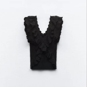 Svart spetsblus med volangdetaljer - Elegant svart blus från Zara med vackra spets- och volangdetaljer. Perfekt för en stilfull look. Är i storlek L men på mig passar den som S