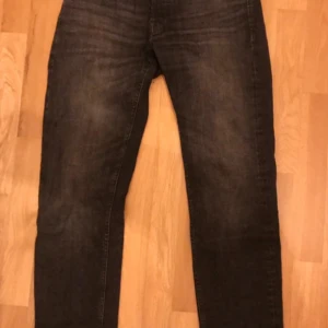 Svarta jeans - Snygga svarta jeans från Jack&Jones. De har en klassisk femficksdesign och passformen tapered/mike. Perfekta för en stilren look. Säljer dem i nyskick! Priset kan förhandlas. Säljer även ett par exakt likadana jeans fast blå. Om du köper båda kan du få båda för 799kr