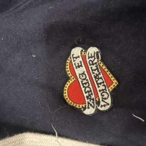 Mörkblå kofta från Zadig & Voltaire - Snygg svart kofta från Zadig & Voltaire med ett  hjärtmärke på bröstet. Den har luva och vita snören också.