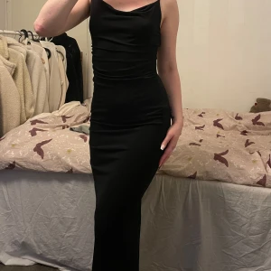 Svart långklänning - Elegant svart långklänning från bershka. Använd 1 tillfälle. Öppen i ryggen och slit bak nere vid benen. Skön stretchigt material.
