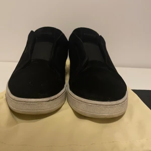 CLEAN 360 LACELESS Axel Arigato - Snygga svarta sneakers från Axel Arigato i en stilren design. Skorna har en vit sula och är tillverkade i mocka med diskreta detaljer. Perfekta för en minimalistisk look.  Använd ett par gånger och säljs pga det inte längre passar. 