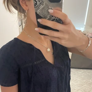 Mörkblå blus från Esprit - Säljer en elegant mörkblå blus från Esprit med korta ärmar och v-ringning. Blusen har ett diskret prickigt mönster och fina spetsdetaljer. Är i storlek XS men passar också dom som har S/M