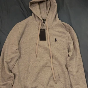 Grå hoodie från Polo Ralph Lauren - Säljer en stilren grå hoodie från Polo Ralph Lauren med det klassiska logo på bröstet. Storlek: M