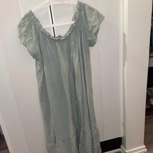 Ljusgrön klänning med puffärmar - Charmig ljusgrön klänning med puffiga kortärmar och en avslappnad passform. Perfekt för varma dagar med sin luftiga design och mjuka material.