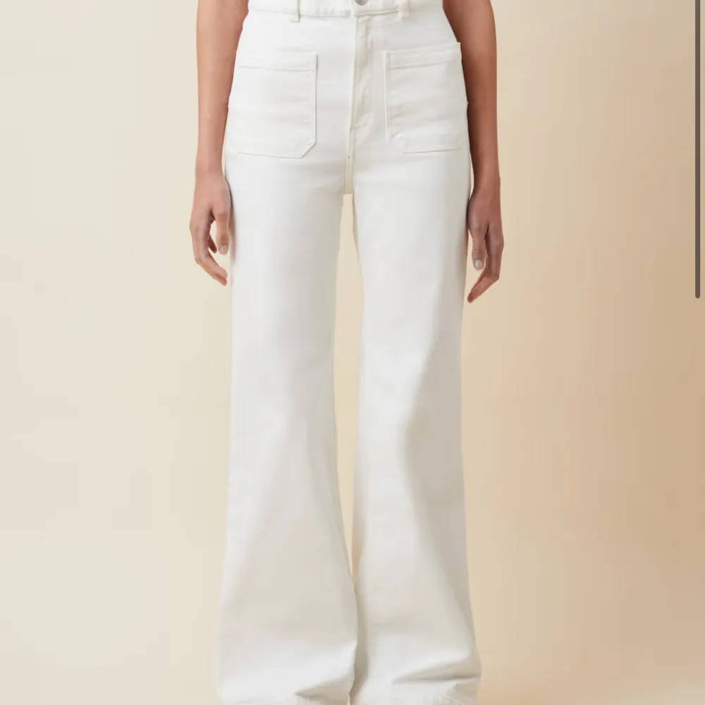 Snygga vita byxor från NA-KD med hög midja och vida ben. Byxorna har framfickor och en knappstängning. Perfekta för en stilren look.. Farkut & Housut.