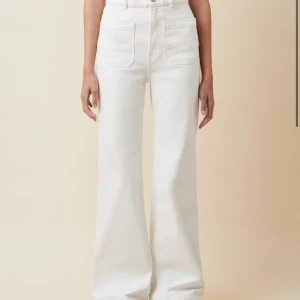 Vita byxor från NA-KD - Snygga vita byxor från NA-KD med hög midja och vida ben. Byxorna har framfickor och en knappstängning. Perfekta för en stilren look.