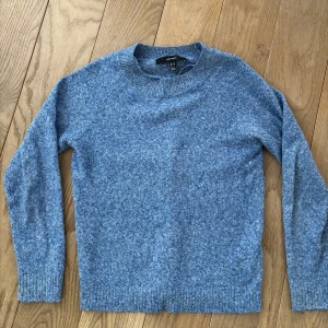 Blå stickad tröja från Vero Moda - Säljer en mysig blå stickad tröja från Vero Moda. Tröjan har en klassisk rund hals och långa ärmar, perfekt för kyligare dagar. Den är i en fin blå nyans som passar till det mesta. Perfekt för att hålla sig var. I bilderna ser tröjan ut att vara i olika färger men det är bara olika ljus, den är använd men är i bra skick, utan skador eller fläckar, dock är den lite knopprig.