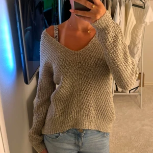 Beige stickad tröja - Mysig beige stickad tröja med v-ringad hals och långa ärmar. Perfekt för kyligare dagar och ger en avslappnad stil. Passar bra till jeans för en casual look men går också att klä upp lätt. Storlek xs och jag säljer för 260kr
