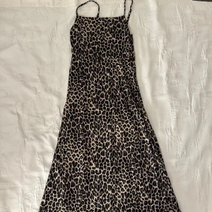 Leopardmönstrad klänning med smala axelband - Säljer en supercool leopardmönstrad maxiklänning med smala axelband. Klänningen har en figurnära passform upptill och faller sedan fint med en slits. Materialet känns lätt och bekvämt mot huden. Ett måste för garderoben om du älskar djurmönster!🎀