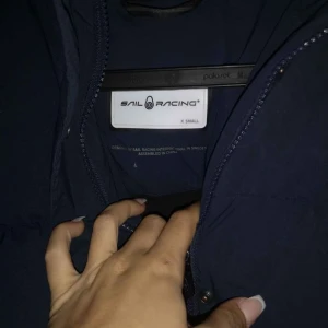 Sail racing jacka - Sail racing dunjacka. Lång modell. Är i fint skick. Inga hål eller skador. Marinblå färg. 