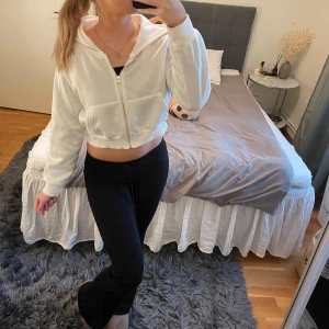 Vit croppad hoodie - Säljer en supermjuk och skön vit croppad hoodie. Den har en dragkedja framtill och långa ärmar. Perfekt för en avslappnad look eller när du bara vill mysa hemma. Passar bra till både jeans och leggings!