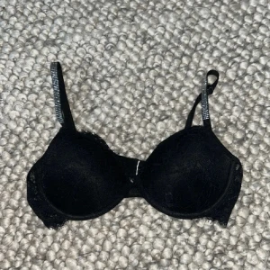 Svart bh med spetsdetaljer - Säljer en elegant svart bh med spetsdetaljer. Den har justerbara axelband och en bekväm passform. Perfekt för både vardag och speciella tillfällen.