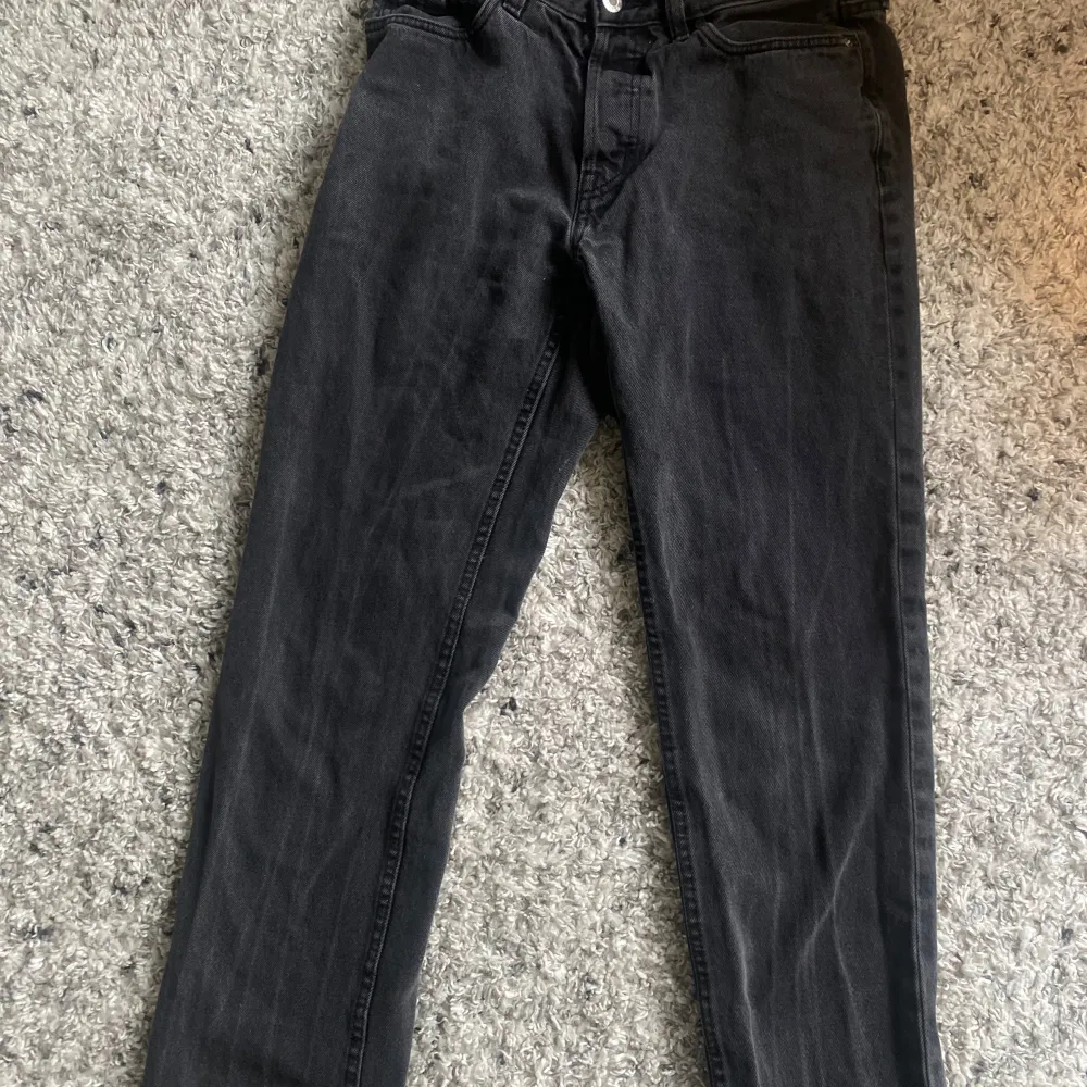 Säljer ett par svarta jeans i regular fit. De är i storlek 31/32 och har en klassisk design med knapp och dragkedja framtill. Perfekta för både vardag och fest!. Farkut & Housut.