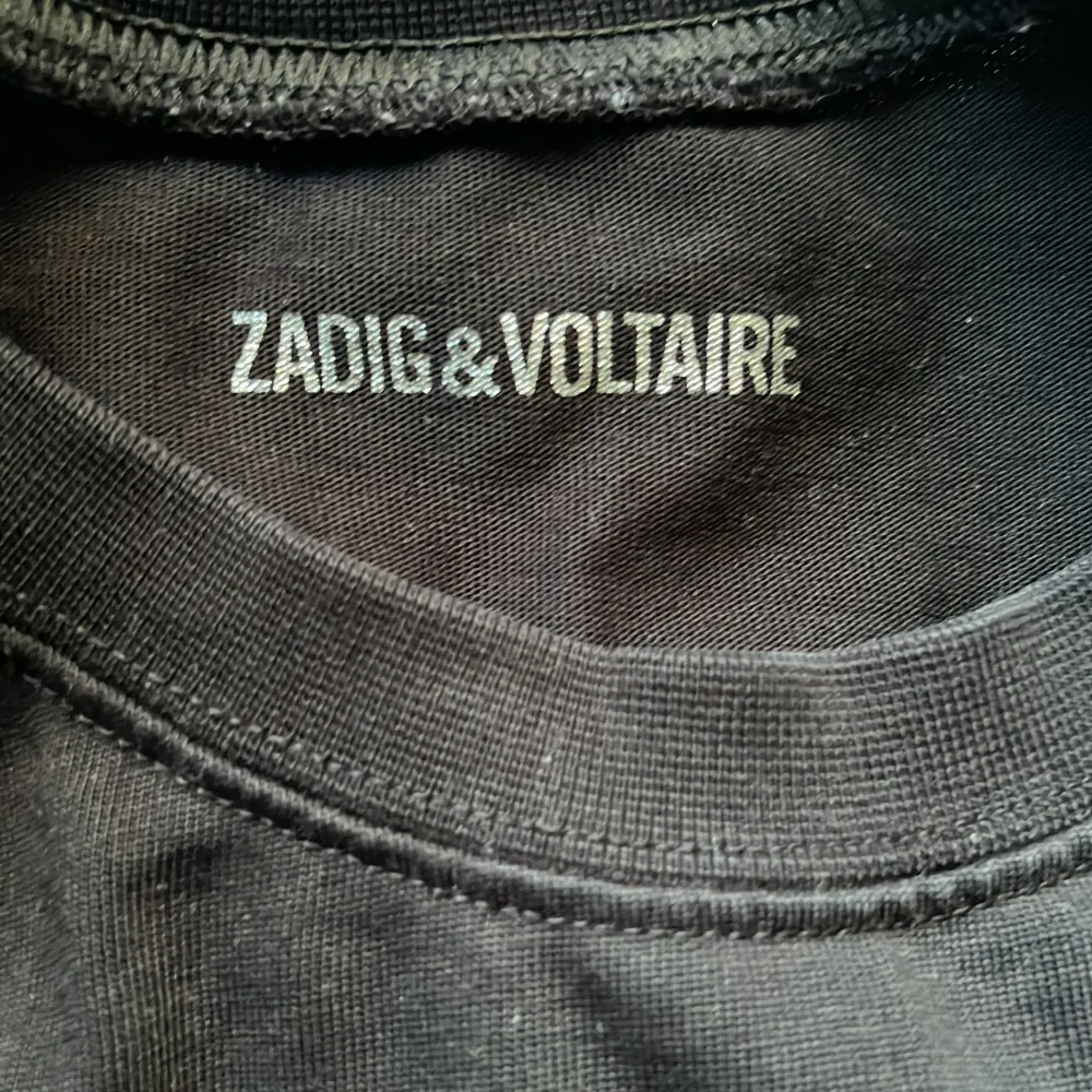 Säljer en cool svart t-shirt från Zadig & Voltaire med en stor blixt i silver på framsidan och texten 'JUST ZADIG’. Storlek m men passar också s! Säljer då den inte kommer till användning längre💞💞. T-shirts.