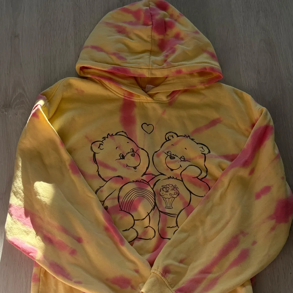 Superfin hoodie i gul och rosa med ett gulligt nalletryck på framsidan. Perfekt för mysiga dagar eller när du vill ha något bekvämt och färgglatt. Den har en klassisk passform med långa ärmar och en skön huva.. Tröjor & Koftor.