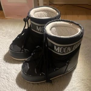 Svarta Moon Boots - Säljer ett par svarta Moon Boots i ganska bra skick. Det ända är att sömmen har gått upp där fram som man kan se på bild 4!💕 De formar sig som fötterna och passar därför 36-38!💕Tveka inte med att höra av dig om fler bilder eller frågor!💕💕