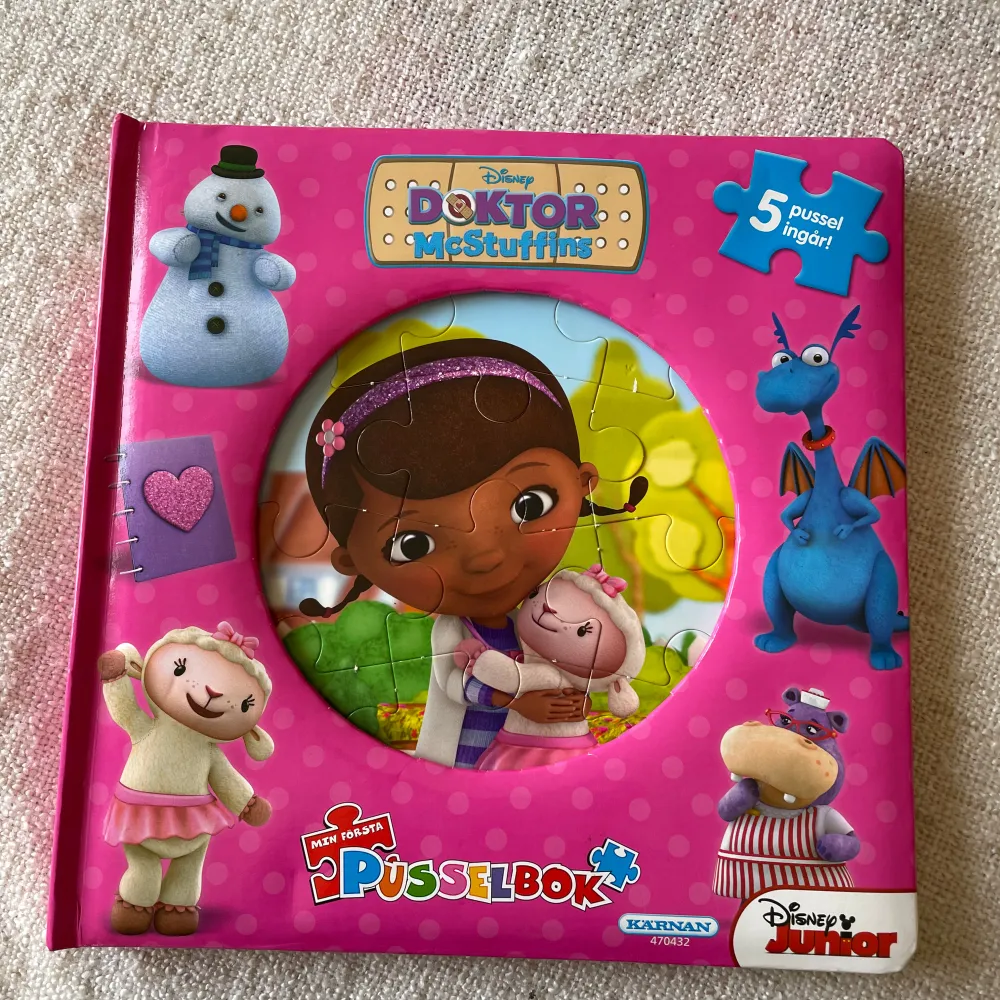 En färgglad och rolig pusselbok med Doktor McStuffins från Disney Junior. Boken innehåller 5 olika pussel som barn kan lägga medan de följer med på äventyr med Doktorn och hennes vänner. Perfekt för små barn som älskar att läsa och pussla samtidigt. Boken har en härlig rosa färg med bilder av karaktärerna på framsidan.. Böcker.