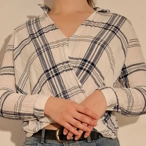 Blårutig blus - Blårutig blus med omlottdetalj.  (Sista bilden visar tröjans material)