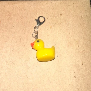 Gul anka nyckelring - Söt liten nyckelring med en gul anka. Perfekt att fästa på väskan eller nyckelknippan för en rolig touch. Ankan är gjord av plast och har en liten karbinhake i silver för enkel fastsättning.