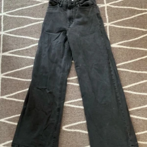 Svarta byxor från Lindex - Säljer ett par svarta byxor från Lindex i storlek 152. De har en loose passform och är perfekta för både vardag och fest. Byxorna är i bra skick och har en klassisk design med knapp och dragkedja framtill.