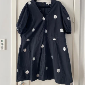 Ny svart tunika med silverfärgade snäckor i strl 50 från nerver fully dressed - Ny svart tunika med silverfärgade snäckor i strl 50 från nerver fully dressed.  Ny, aldrig använd.  Mått Över bröstet: ca 65 cm Längd från axeln och ner: ca 92 cm  100% polyester   Kommer från ett djur och rökfritt hem.