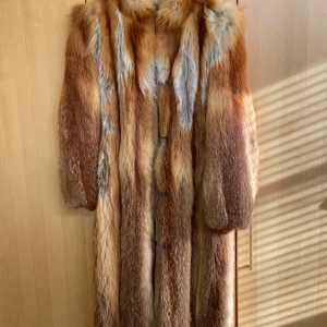 Äkta rödrävspäls vintage - Äkta rödrävspäls, måttsydd stl 38 ca, från Andreasson/Göteborg. Sydd slutet 70-tal. Rundhalsad m liten ståkrage, avtagbara ärmar/blixtlås. Ankellång för längd 165 cm. Mycket fint skick, dock några lagningar i innerfoder/siden vid vänstra armen.