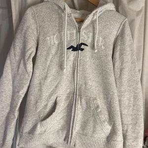 Tröja med luva  - Tröja med zip och luva från Hollister 