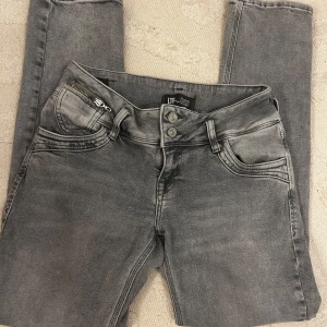 Grå jeans från LTB - Säljer ett par snygga grå jeans från LTB. De har en cool tvättad look och är perfekta för både vardag och fest. Jeansen har en klassisk femficksdesign med dragkedja och knappar framtill. De är i bra skick och redo för en ny ägare!