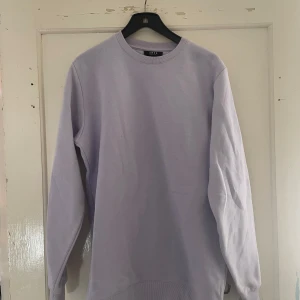 Ljuslila tröja från Smog - Säljer en stilren ljuslila tröja från Smog i storlek M. Tröjan har en regular fit och är perfekt för både vardag och avslappnade tillfällen. Den är långärmad och gjord i ett mjukt material som känns skönt mot huden. Passar perfekt till höst och vår!