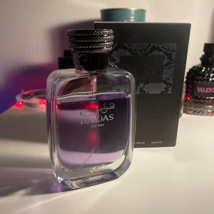 Rasasi Hawas for him - Elegant parfymflaska med lila vätska och en stilren svart kork. Flaskan har en modern design med mjuka kurvor och tydlig märkning. Perfekt för den som söker en sofistikerad doft. Ca 7ml använt 