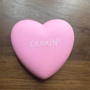 Hjärtformad rouge från ColourPop - Söt hjärtformad rouge från ColourPop. Säljs då jag inte använder puderblush men otrolig färg😍Kompakt design med inbyggd spegel, perfekt för touch-ups när du är på språng. Den intensiva rosa färgen ger en fräsch och trendig look. 