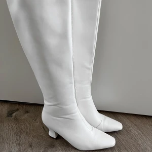 Vita stövlar storlek 40 - Snygga vita stövlar i skinn med dragkedja och spetsig tå. Låg klack, mycket sköna. Använda endast en gång!