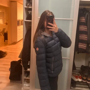 Mörkblå dunjacka med huva - Sä snygg mörkblå dunjacka från colmar, bär storlek XS/S, Dragkedjan funkar! Går att fixa lätt
