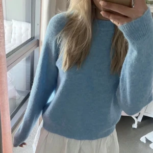 Ljusblå stickad tröja - Säljer en ljusblå stickad tröja med långa ärmar. Perfekt för kyligare dagar och enkel att matcha med olika outfits.