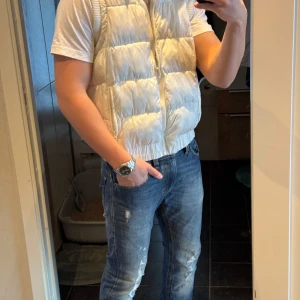 Vit dunväst från Blend - Säljer en snygg vit dunväst från Blend med dragkedja och huva. Lätt att matcha med olika outfits. Den passar mer M än L. Skriv om frågor !!