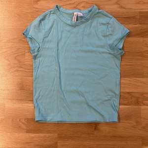 topp från h&m  - Säljer en ljusblå topp från H&M divided i dam storlek XS. Toppen är en tajt och kort modell, den är använd ett fåtal gånger och är i mycket bra skick. ⭐️