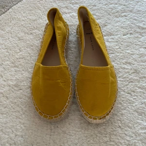 Gula espadrillos från New Look - Snygga gula espadrillos från New Look med klassisk flätad sula. Perfekta för sommardagar och ger en färgglad touch till din outfit. Tillverkade i ett lätt material som andas. Storlek 39 men stora i storlek.