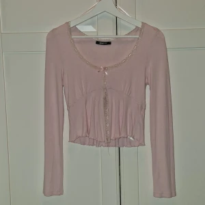Söt Rosa Tröja - •🤍• Säljer denna långarmade tröjan som är öppen i mitten för att färjan passar inte mig 💓 Färgen är ljus rosa och är då som ja sa öppen vid magen nästan upp till bröstkorgen 🌟 Inga defekter och lappen är kvar! •🤍•
