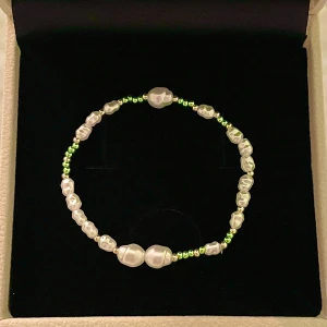 Pärlarmband med gröna detaljer - Säljer massa fler armband!  Egentillverkat armband. Armbandet är gjort på en elastisk tråd vilket innebär att den är stretchig och därmed passar flera storlekar☺️  Pris går tyvärr inte att sänk på just armbanden jag säljer, eftersom materialet att tillverka dem kostar en del. Frakt 22kr icke spårbar, 59kr spårbar. Betalning sker via Swish för att kunna skicka med icke spårbar! Bara att skriva vid frågor🤗🌴🌸🌊🥥🥭🩷🍹