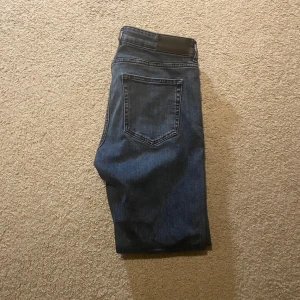 Slim fit jeans  - Snygga blå jeansbyxor med klassisk femficksdesign. De har en rak passform och är perfekta för en avslappnad stil. Byxorna har en dragkedja