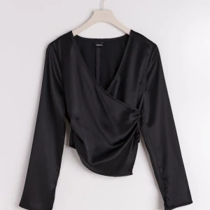 Svart satin blus från Gina tricot - Jättefin satin blus från Gina tricot, endast använd fåtal gånger. Säljer på grund av att den ej kommer till användning. 