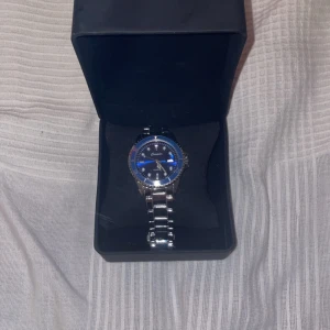 Silverklocka - Snygg silverklocka med blått runt.