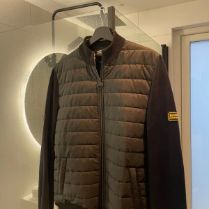 Barbour Cardigan Svart - Dags för mig att sälja min Barbour cardigan som är svart, perfekt cardigan jacka att ha över huvtröjor nu under hösten. Endast använd under våren/sommaren. skick 9/10, väldigt fint skick på jackan och inga defekter. Kom med era bud!!!!