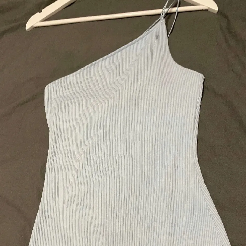 Säljer en superfin ljusblå klänning med en stilren oneshoulder-design. Klänningen framhäver dina fina kurvor. Perfekt för sommarens alla fester eller en utekväll med vännerna. Klänningen är i fint skick😍 . Mekot.