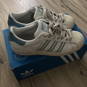 Adidas superstars ljusblå - snörena något slitna annars väldigt bra skick               nypris 1299kr